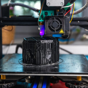 A 3D printer prints a black model. Technology at home